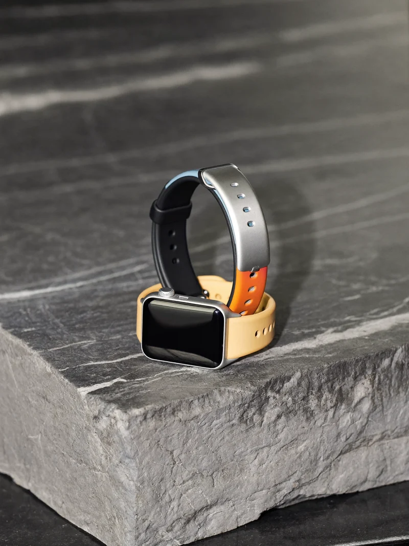 Montre connectée et bracelet d'activité à sangles colorées sur une dalle de pierre grise